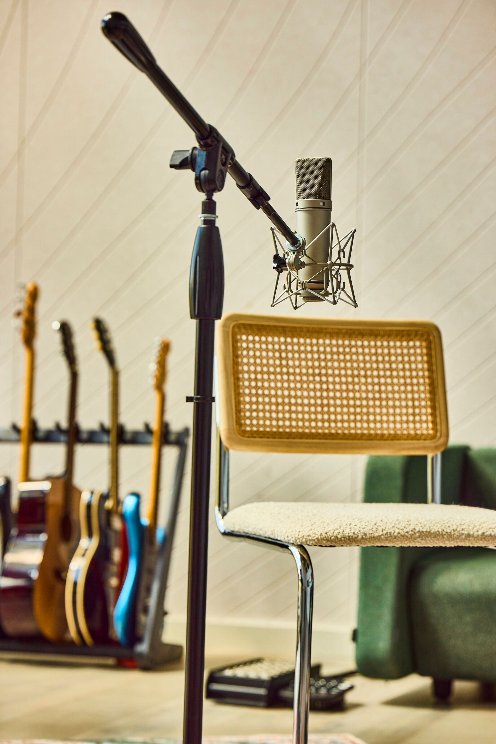 Neumann condenser microphone on stand with guitar rack in the Verdant Sound live room