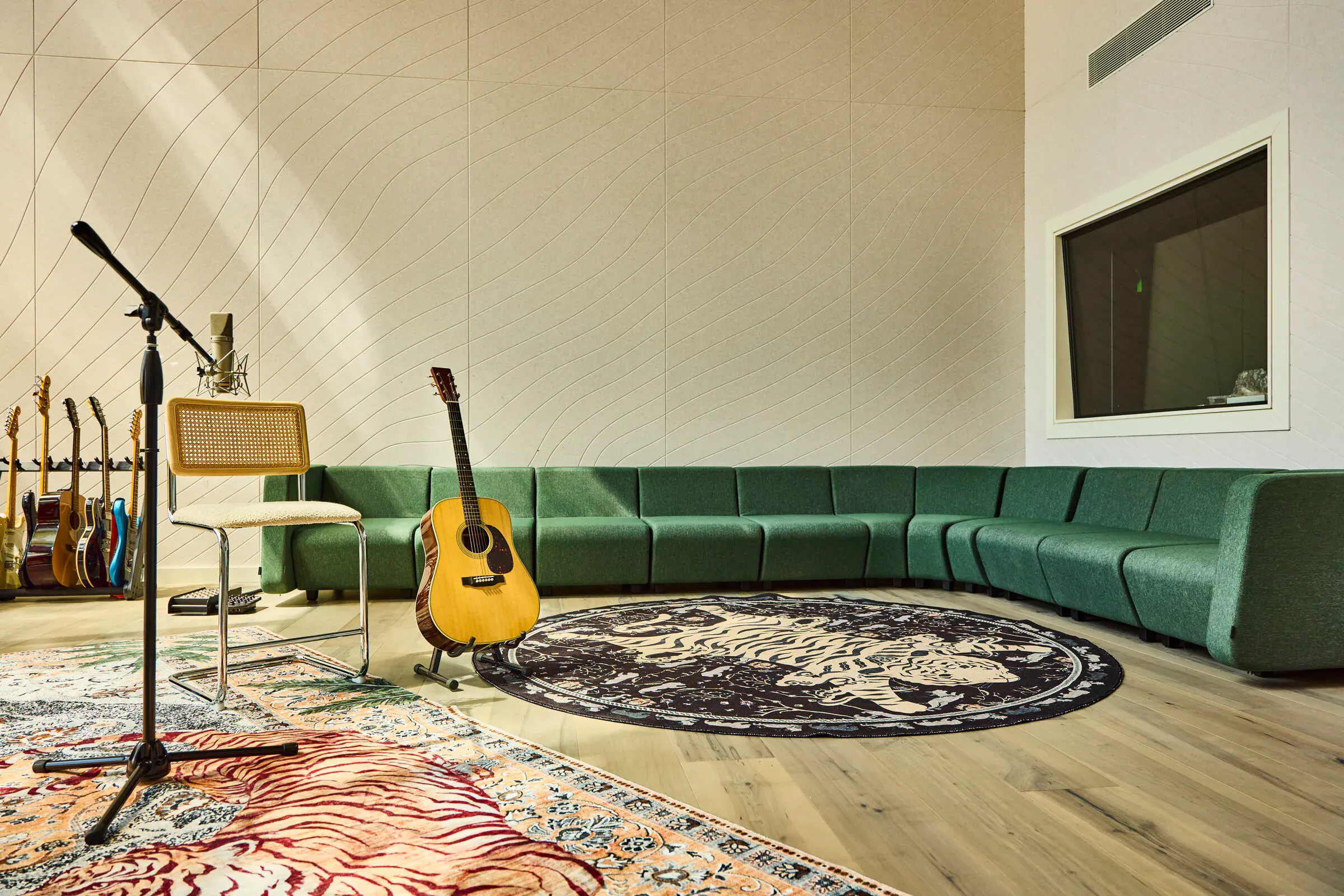 Green velvet sectional sofa and guitar rack in the Verdant Sound live room